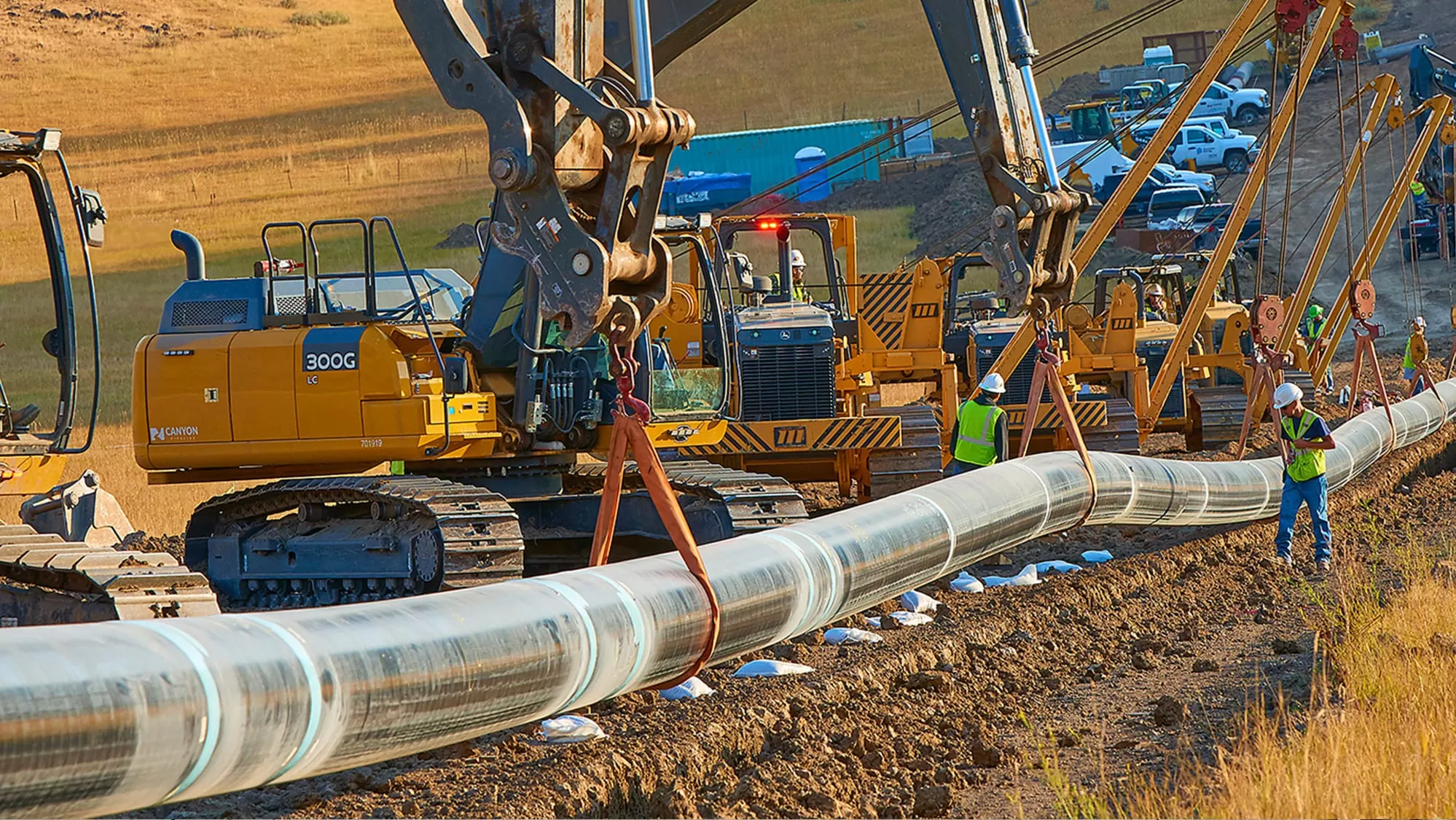 crew members laying miles of pipe in a valley