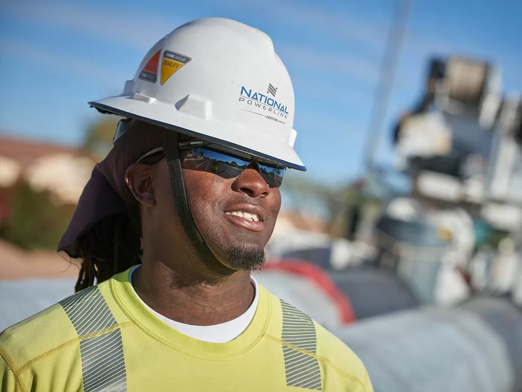 Black employee with hard hat on smiling