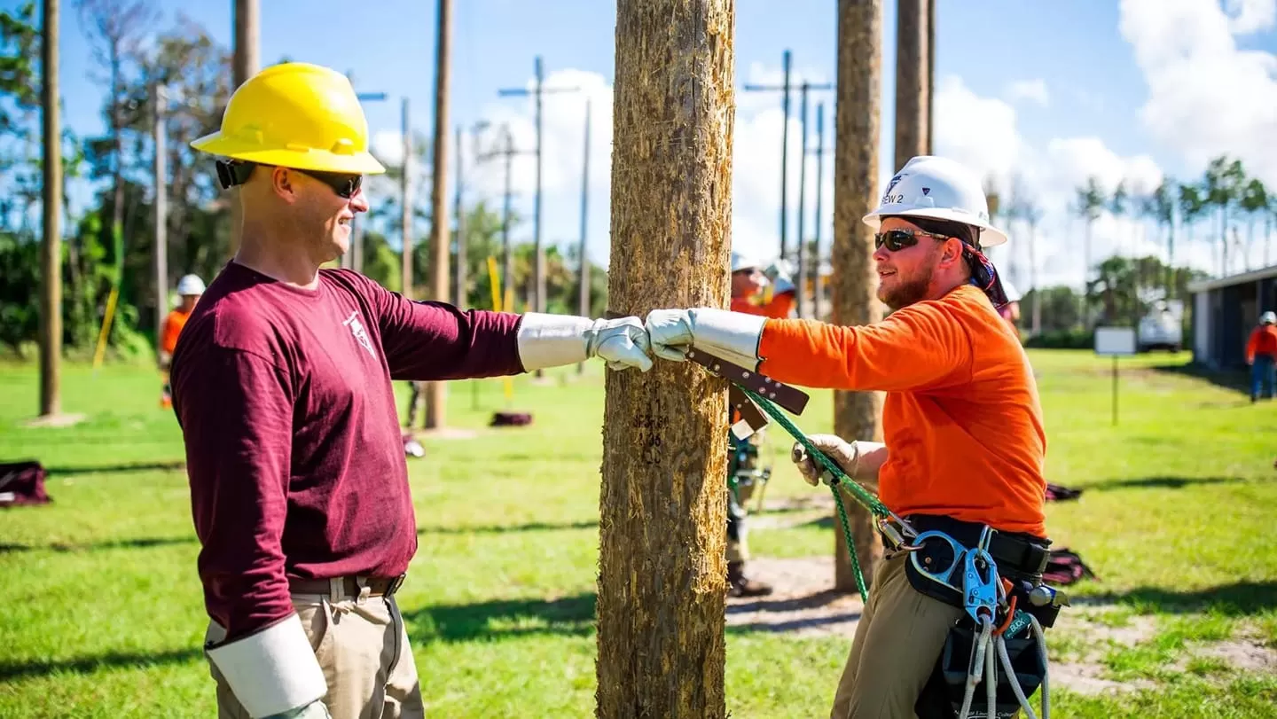 two students at lineman college fist bump
