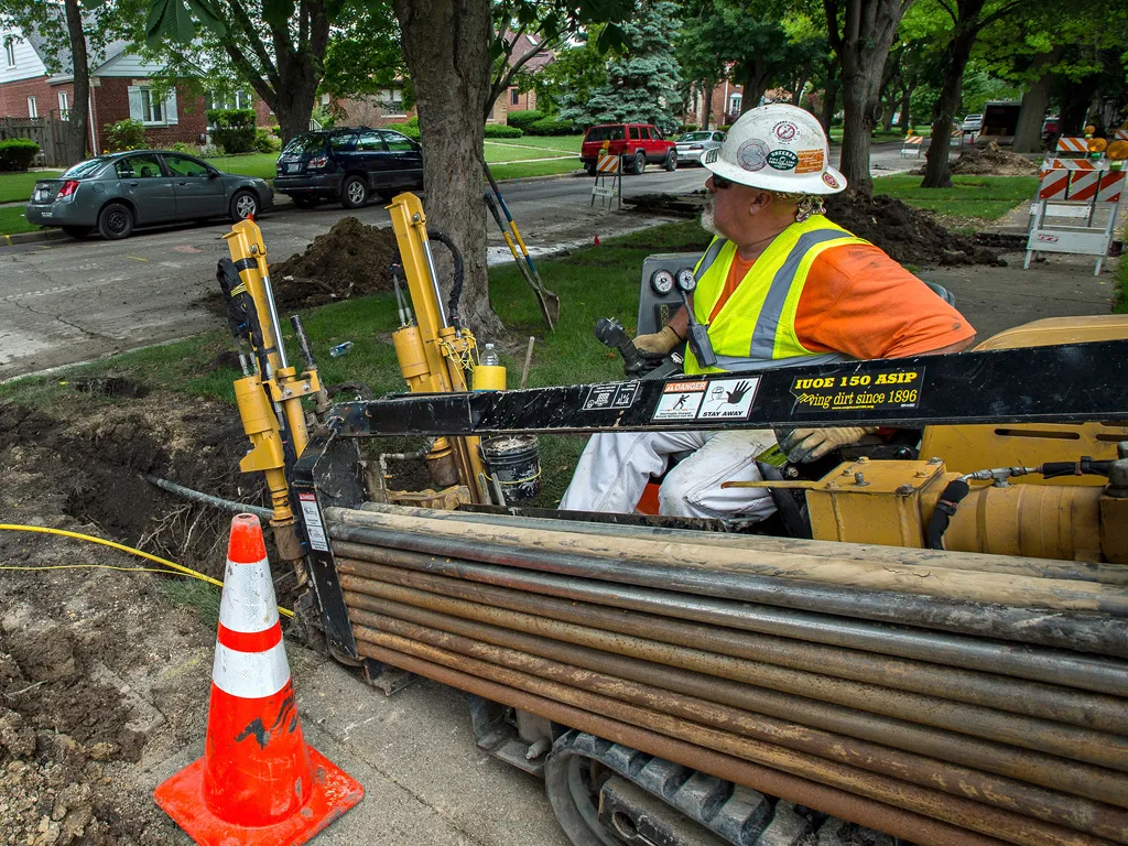 Driller operating drill under residential road