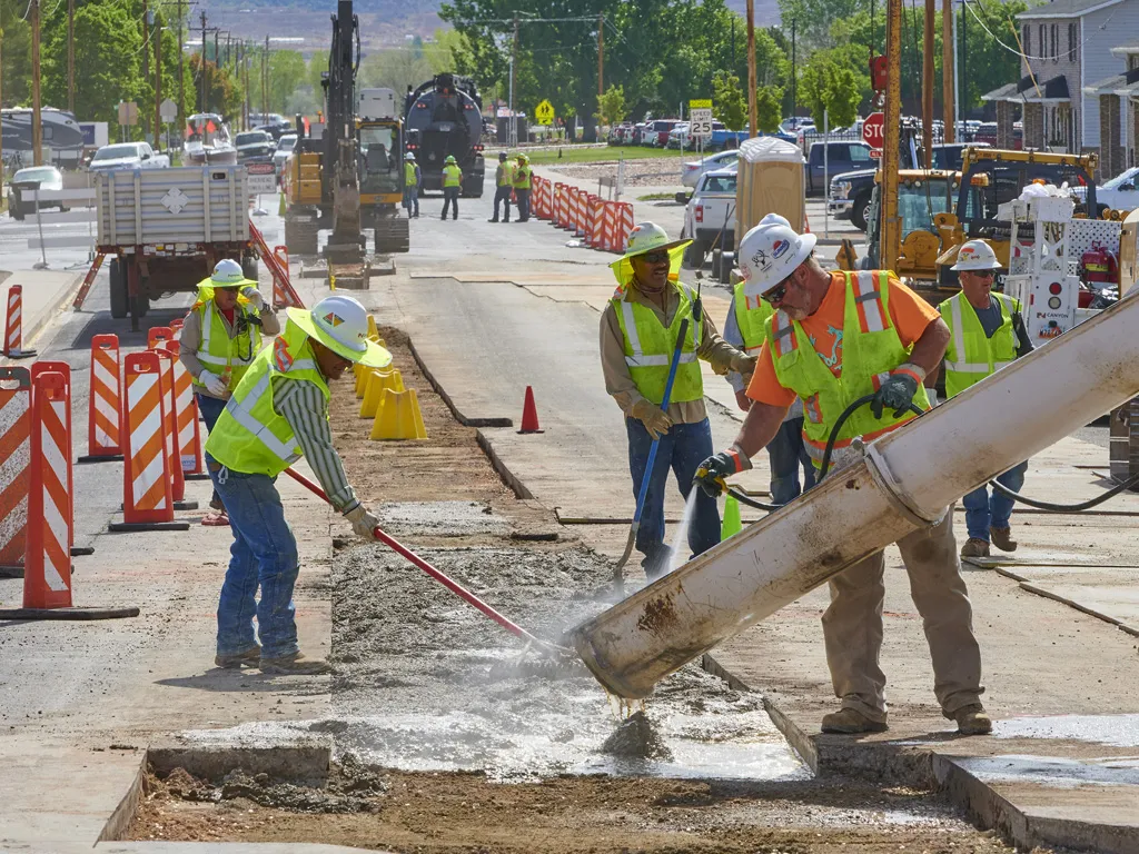 Pavers on road worksite spreading cement