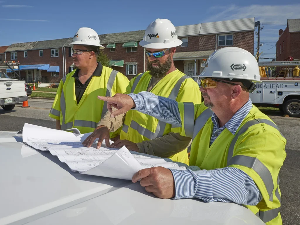 three workers on a construction site, planning details